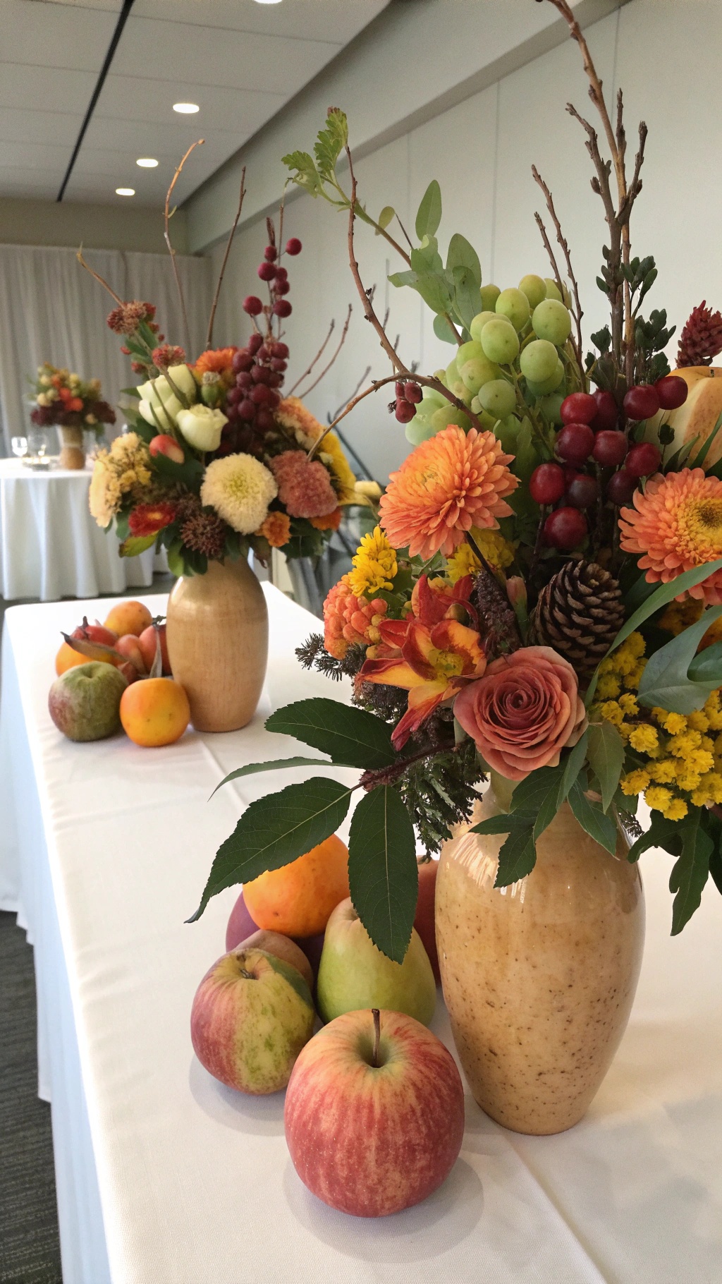 Autumn-inspired centerpieces featuring colorful flowers and fresh fruits.